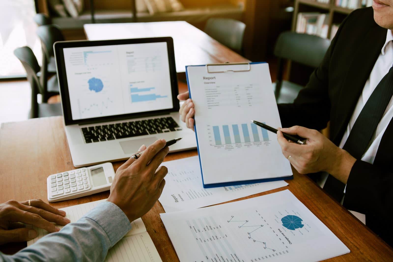 Charts and a laptop on a desk during a portfolio review